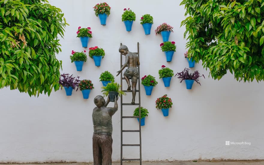 Bronze figure of a grandfather and his grandson taking care of plants and flowers, Cordoba, Spain