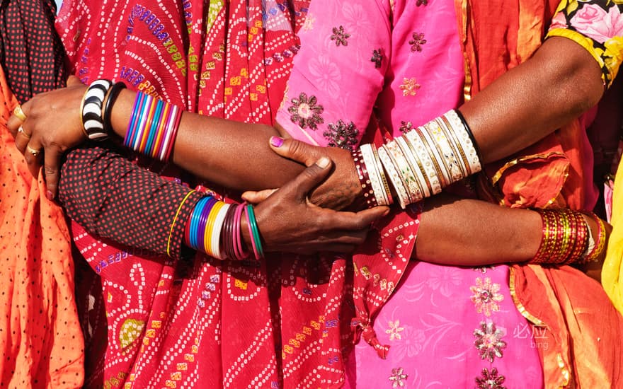 Women in traditional Indian costumes close together